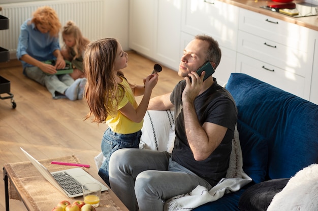 Eltern, die versuchen, von zu Hause aus zu arbeiten, umgeben von Kindern