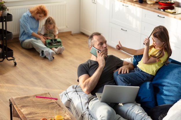 Eltern, die versuchen, von zu Hause aus zu arbeiten, umgeben von Kindern