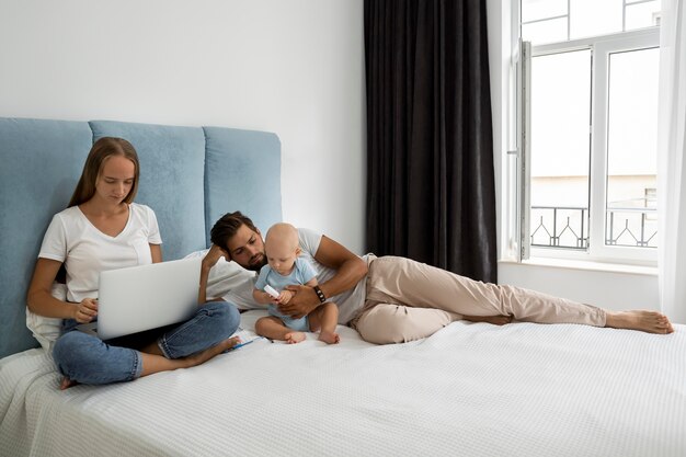Eltern, die von zu Hause aus während der Quarantäne mit dem Kind am Laptop arbeiten