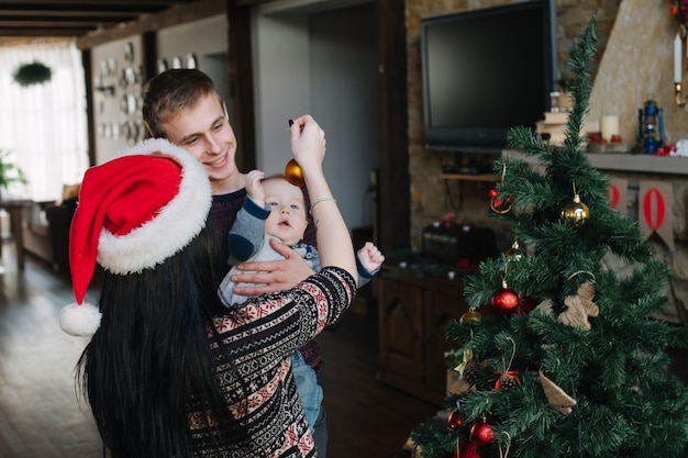 Eltern ihr Kind eine Weihnachtskugel zeigt
