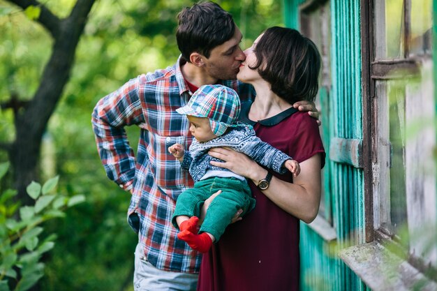 Eltern küssen halten Baby im Freien