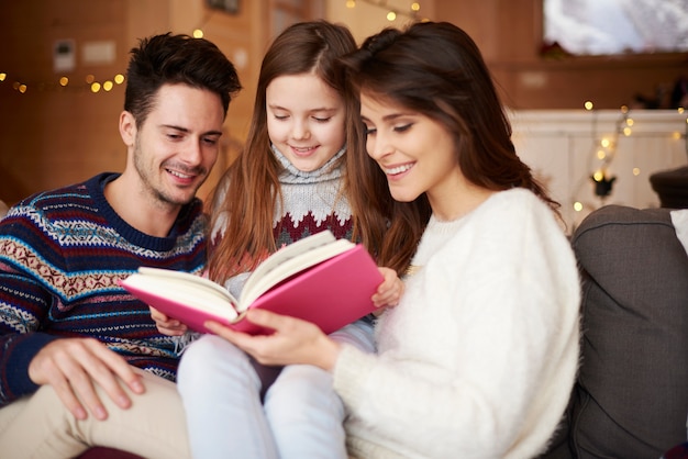 Eltern mit Tochter lesen Märchen