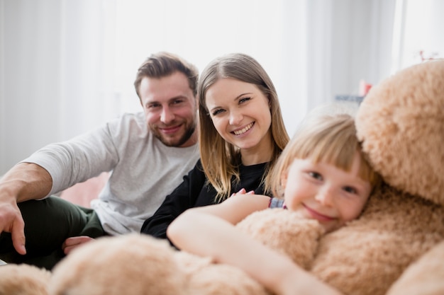 Kostenloses Foto eltern nähern sich mädchen mit spielzeug