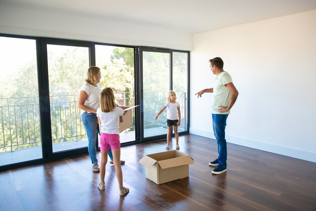 Eltern und ihre Kinder unterhalten sich beim Umzug in ein neues Haus