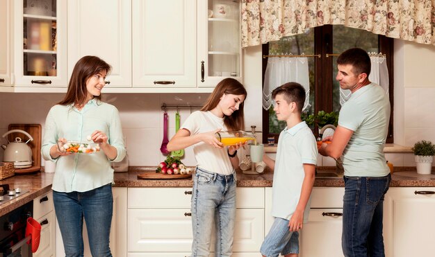 Eltern und Kinder bereiten Essen in der Küche zu