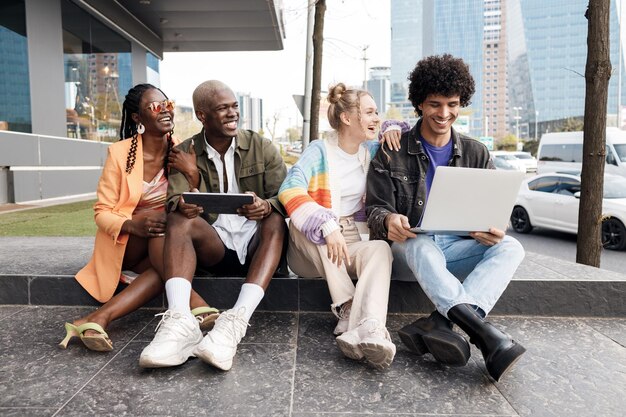 emotionale freunde, die draußen am laptop arbeiten