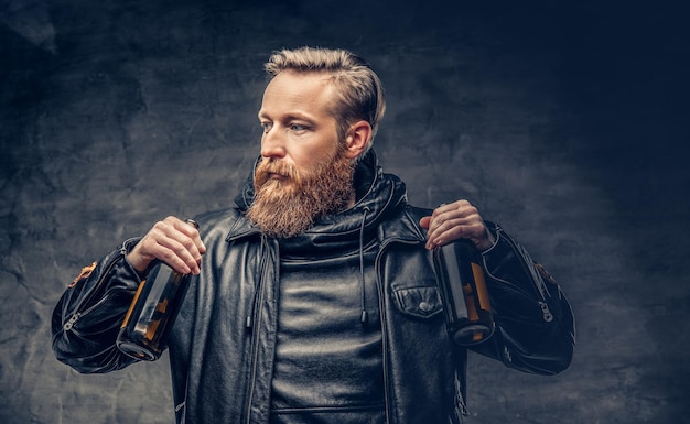 Emotionaler, lustiger, rothaariger, bärtiger, betrunkener Hipster-Mann hält Craft-Flaschenbier.