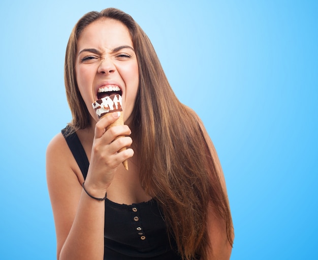 Emotionales Mädchen beißt Eis.