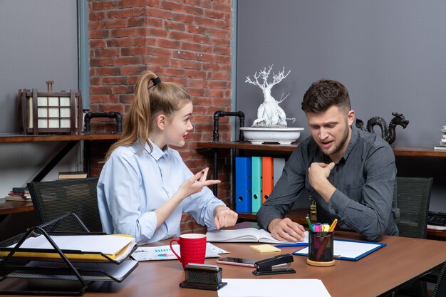 Emotionales Managementteam, das am Tisch im Besprechungsraum in der Büroumgebung sitzt sitting