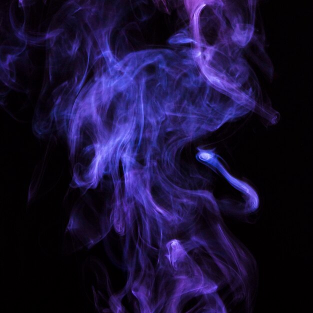 Empfindliche purpurrote Zigarettenrauchbewegung auf schwarzem Hintergrund
