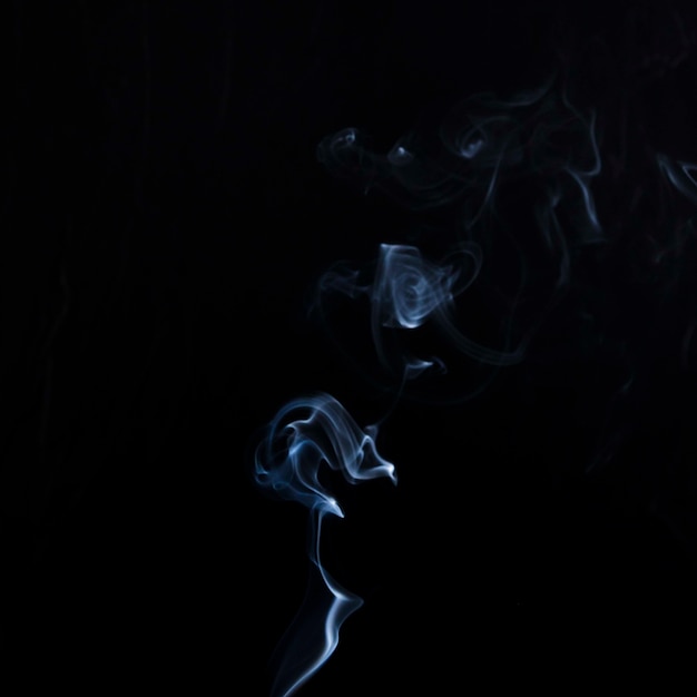 Empfindliche weiße Zigarettenrauchbewegung auf schwarzem Hintergrund