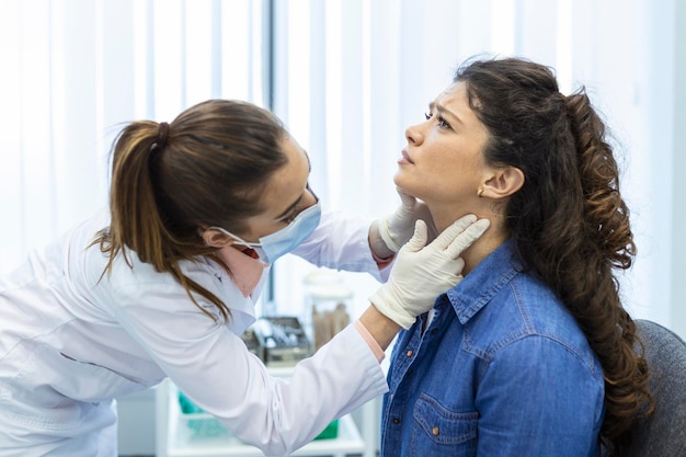 Endokrinologe untersucht den Hals einer jungen Frau in der Klinik Frauen mit Schilddrüsentest Endokrinologische Hormone und Behandlung Entzündung der Halsschmerzen