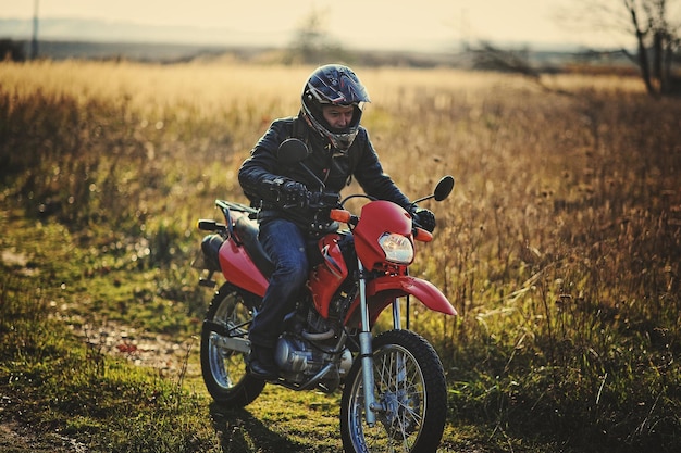 Enduro-rennfahrer sitzt auf seinem motorrad