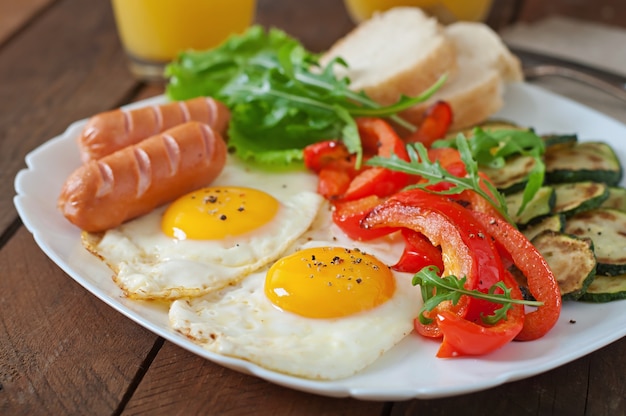 Englisches Frühstück - Spiegeleier, Würstchen, Zucchini und Paprika