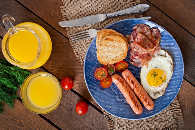 Englisches Frühstück - Toast, Ei, Speck und Gemüse im rustikalen Stil auf Holztisch