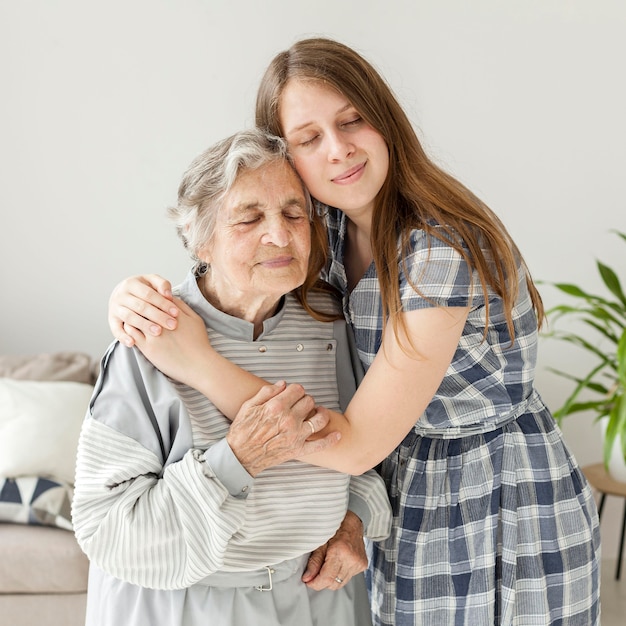 Enkelin, die Großmutter mit Liebe umarmt