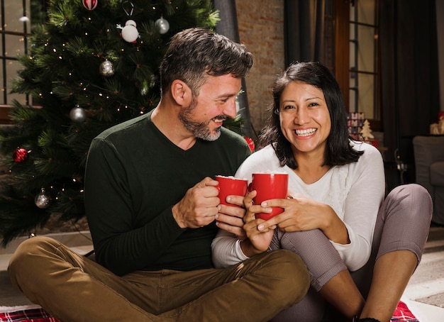 Enoying heiße Getränke der glücklichen älteren Weihnachtspaare