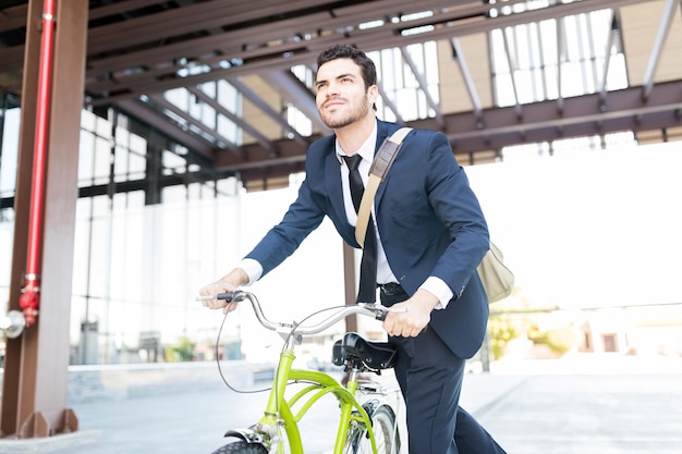 Entschlossener Manager im eleganten Anzug mit Oldtimer-Fahrrad in der Stadt