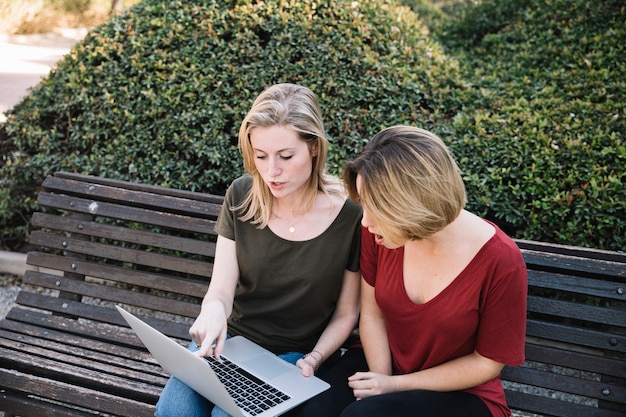 Entsetzte Frauen, die auf Laptopbildschirm zeigen