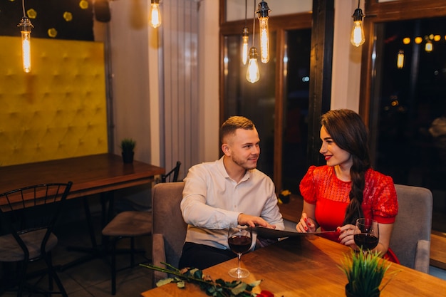 Entspannende Paare, die Abendessen im Café genießen