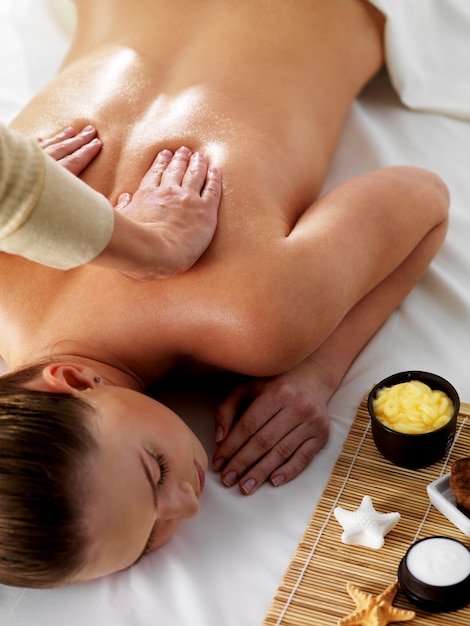 Kostenloses Foto entspannung und freude an der massage für junge schöne frau im spa-schönheitssalon - vertikal