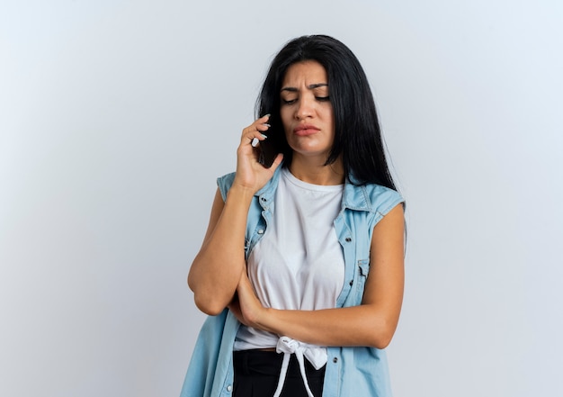 Enttäuschte junge kaukasische Frau spricht am Telefon