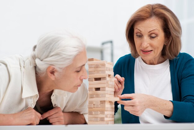 Entzückende Frauen, die zusammen jenga spielen