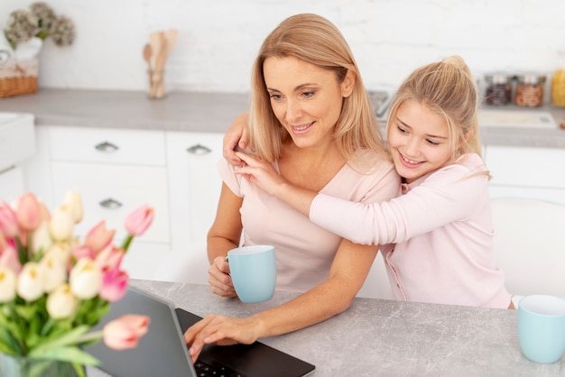 Entzückende Tochter, die ihre Mutter umfasst