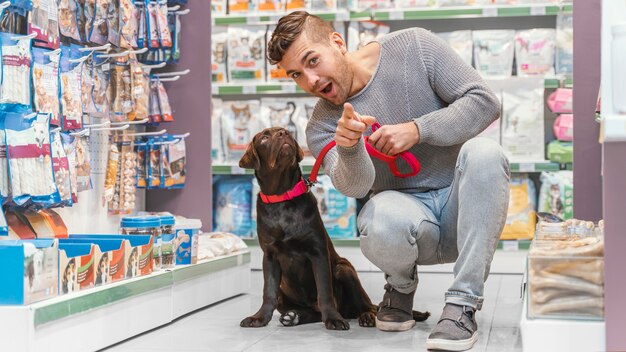 Entzückender Hund mit Besitzer in der Tierhandlung