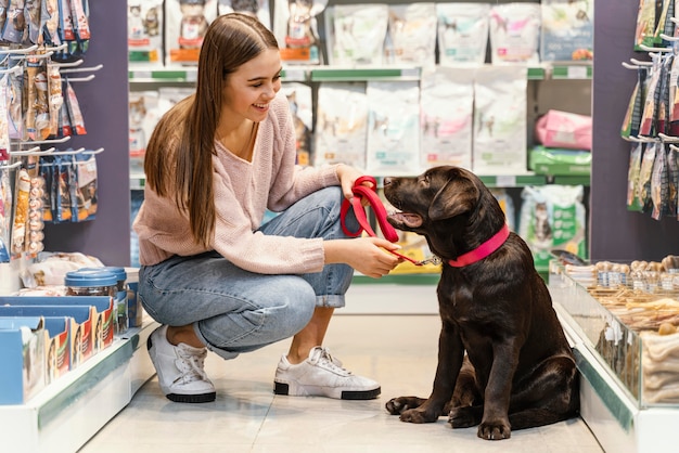 Entzückender Hund mit Besitzerin in der Tierhandlung