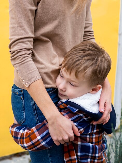 Entzückender Junge, der seine Mutter hält