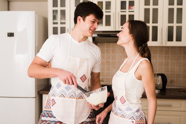 Entzückender junger Mann und Frau, die zusammen kocht
