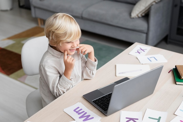 Entzückender kleiner Junge, der eine Online-Sitzung zur Sprachtherapie macht