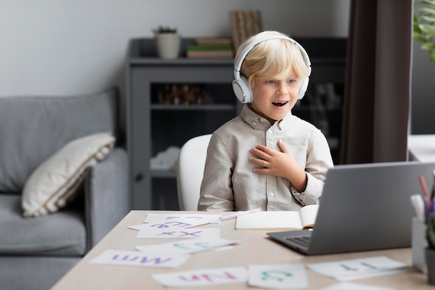 Entzückender kleiner Junge, der eine Online-Sitzung zur Sprachtherapie macht