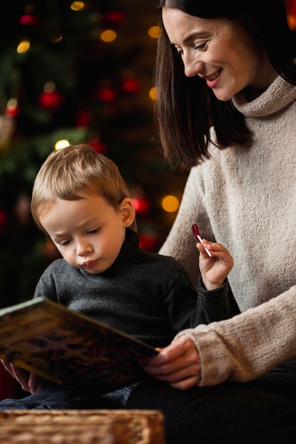 Entzückender kleiner junge, der mit weihnachtsspielzeug spielt