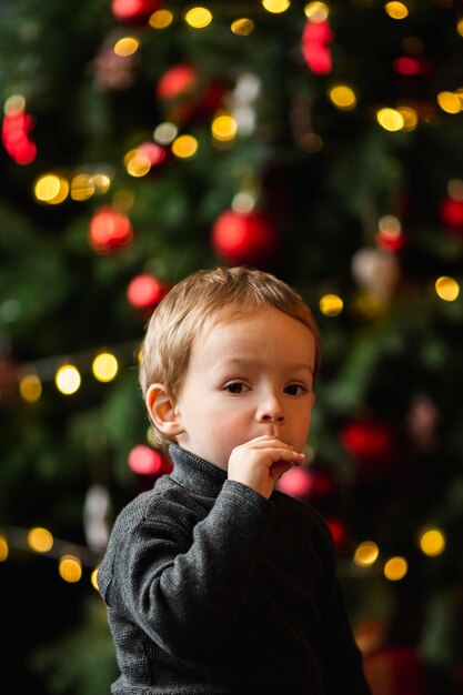 Entzückender kleiner Junge, der mit Weihnachtsspielzeug spielt