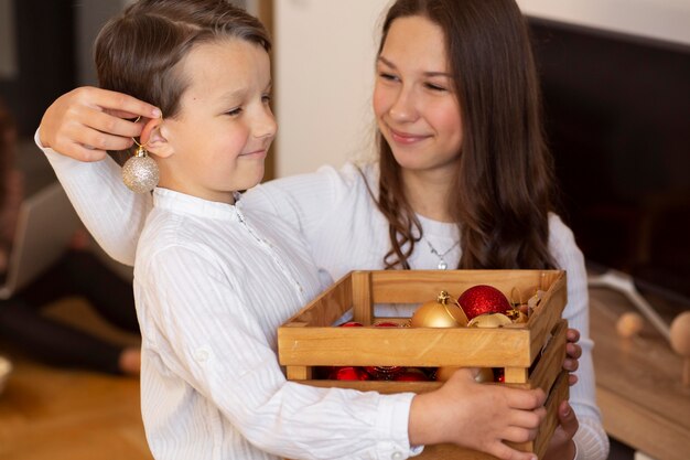 Entzückender kleiner Junge mit seiner Schwester an Weihnachten