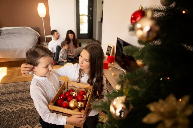 Entzückender kleiner Junge mit seiner Schwester an Weihnachten