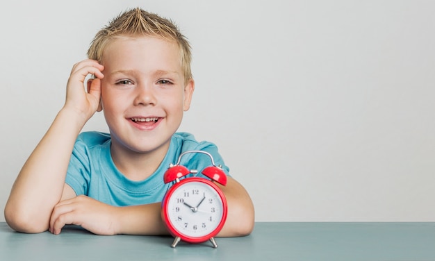 Entzückender smileyjunge mit einer Uhr