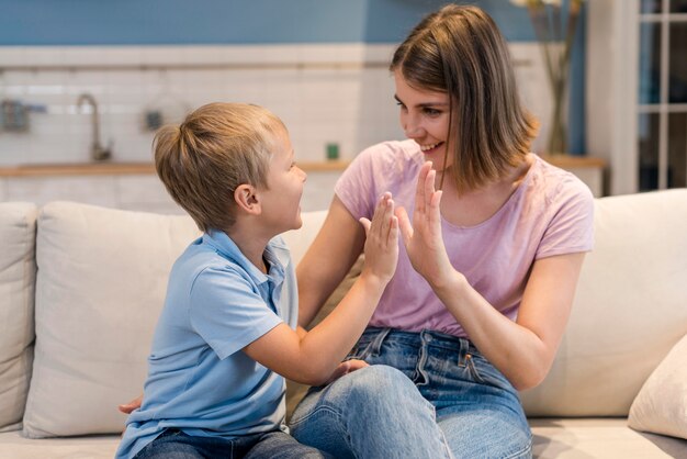 Entzückender Sohn der Vorderansicht, der mit Mutter spielt