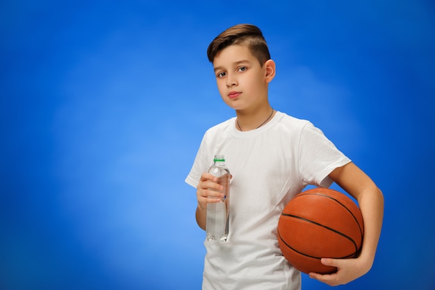 Entzückendes 11 Jahre altes Jungenkind mit Basketballball