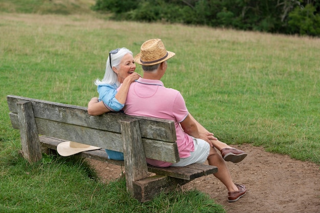 Entzückendes älteres Paar, das auf einer Bank sitzt
