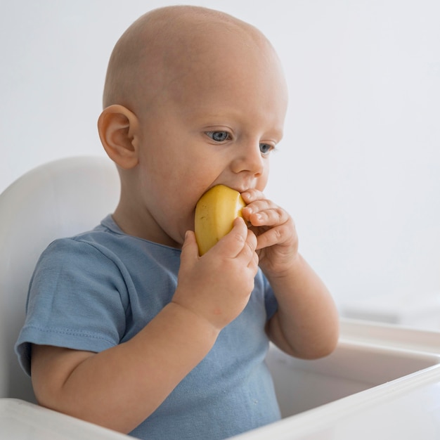 Entzückendes Baby, das mit Essen spielt