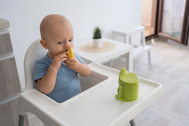 Entzückendes Baby, das mit Essen spielt