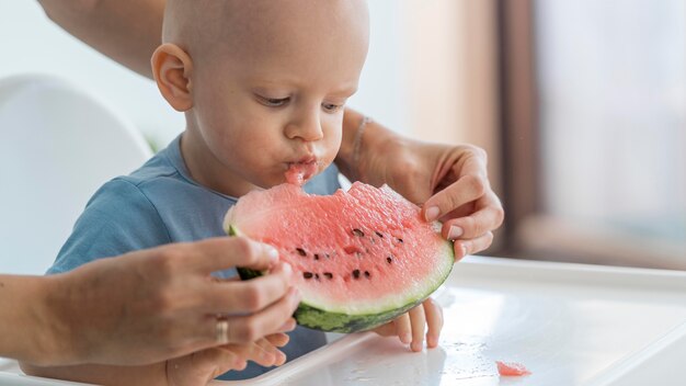 Entzückendes Baby, das mit Essen spielt