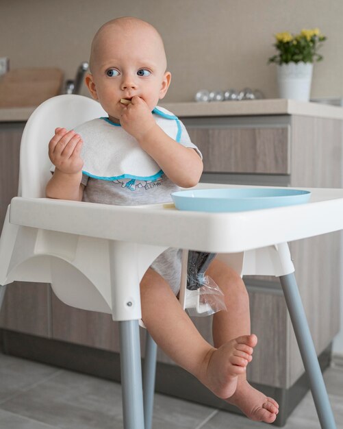 Entzückendes Baby, das mit Essen spielt