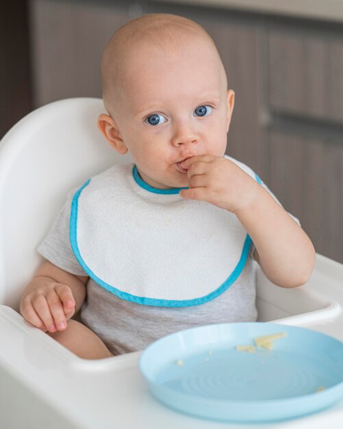 Entzückendes Baby, das mit Essen spielt