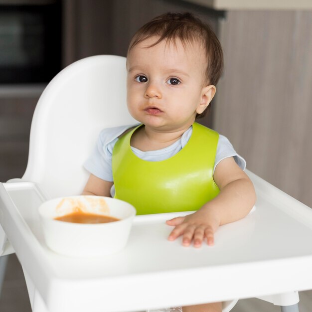 Entzückendes Baby, das mit Essen spielt