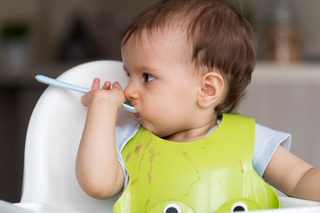 Entzückendes Baby, das mit Essen spielt