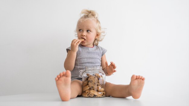 Entzückendes Baby, das mit Essen spielt